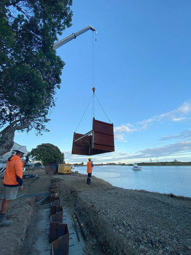 Temporary retaining wall being lifted into place.