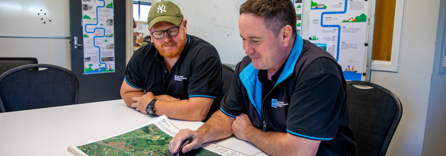 Two men looking at a mpa