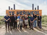 People standing in front of Te Heriheri wetland sign