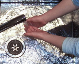 Washing hands under the tap in a sink