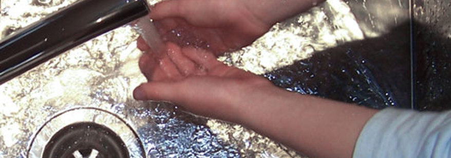 Washing hands under the tap in a sink